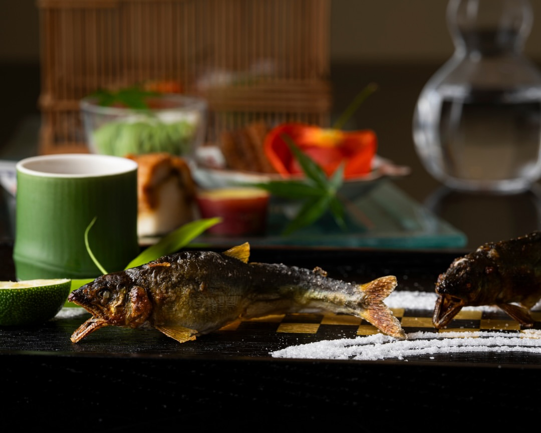 旬の恵みを一皿一皿に。鮎や鱧、夏野菜など、季節を彩る食材を丁寧に調理した京懐石をご用意しました。香ばしく焼き上げた鮎の塩焼きや、鮎の旨味と出汁が染み渡る人気の釜炊き御飯は、この季節ならではの味わい。京